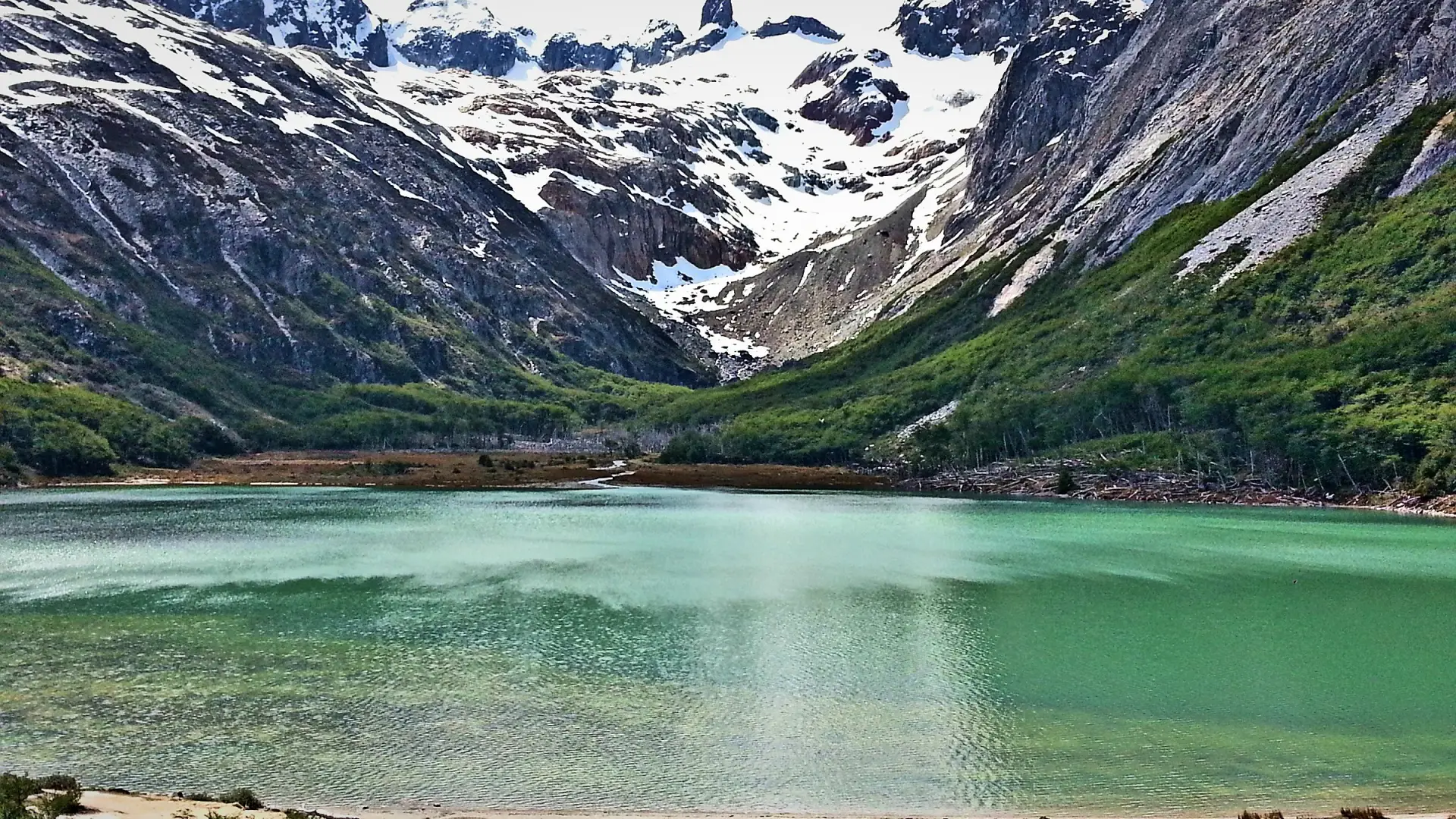 La Laguna Esmeralda, de agua verde turquesa, al pie de montañas con nieve, cerca de Ushuaia