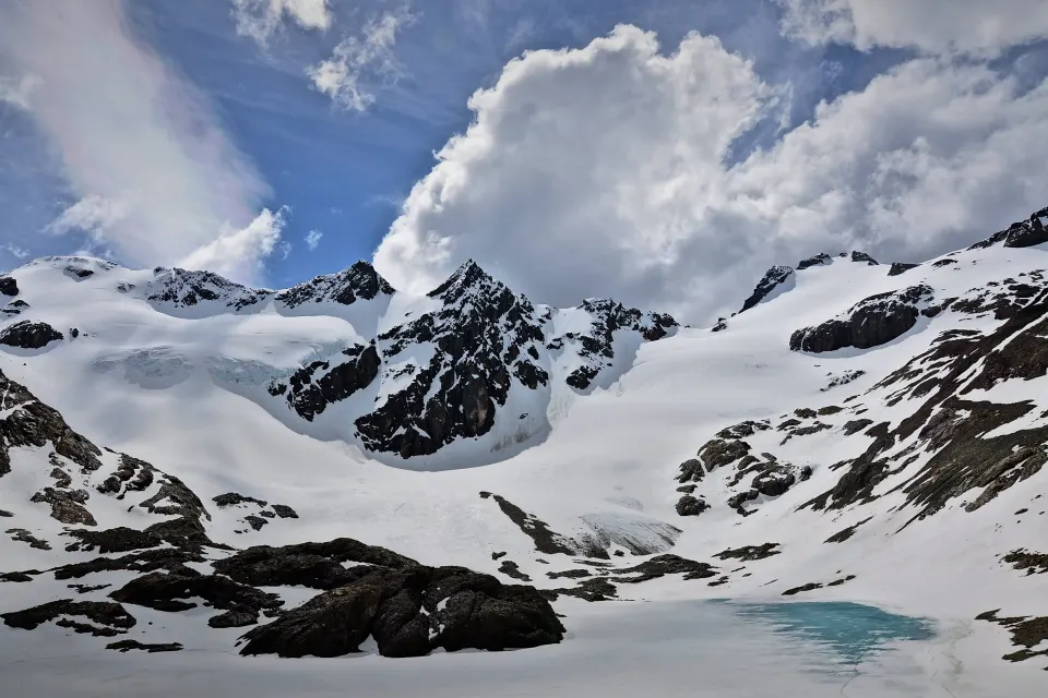 El Glaciar Vinciguerra cubierto de nieve, con la Laguna de los Témpanos a sus pies y nubes sobre las cumbres