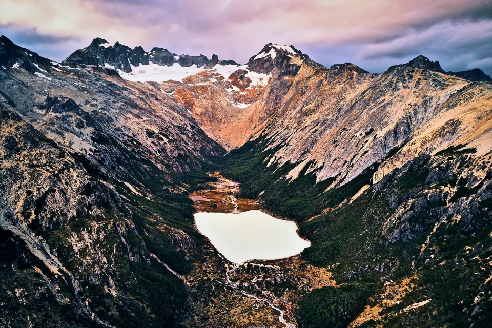 Vista aérea de la Laguna Esmeralda en su valle, con el Glaciar Ojo del Albino entre las cumbres