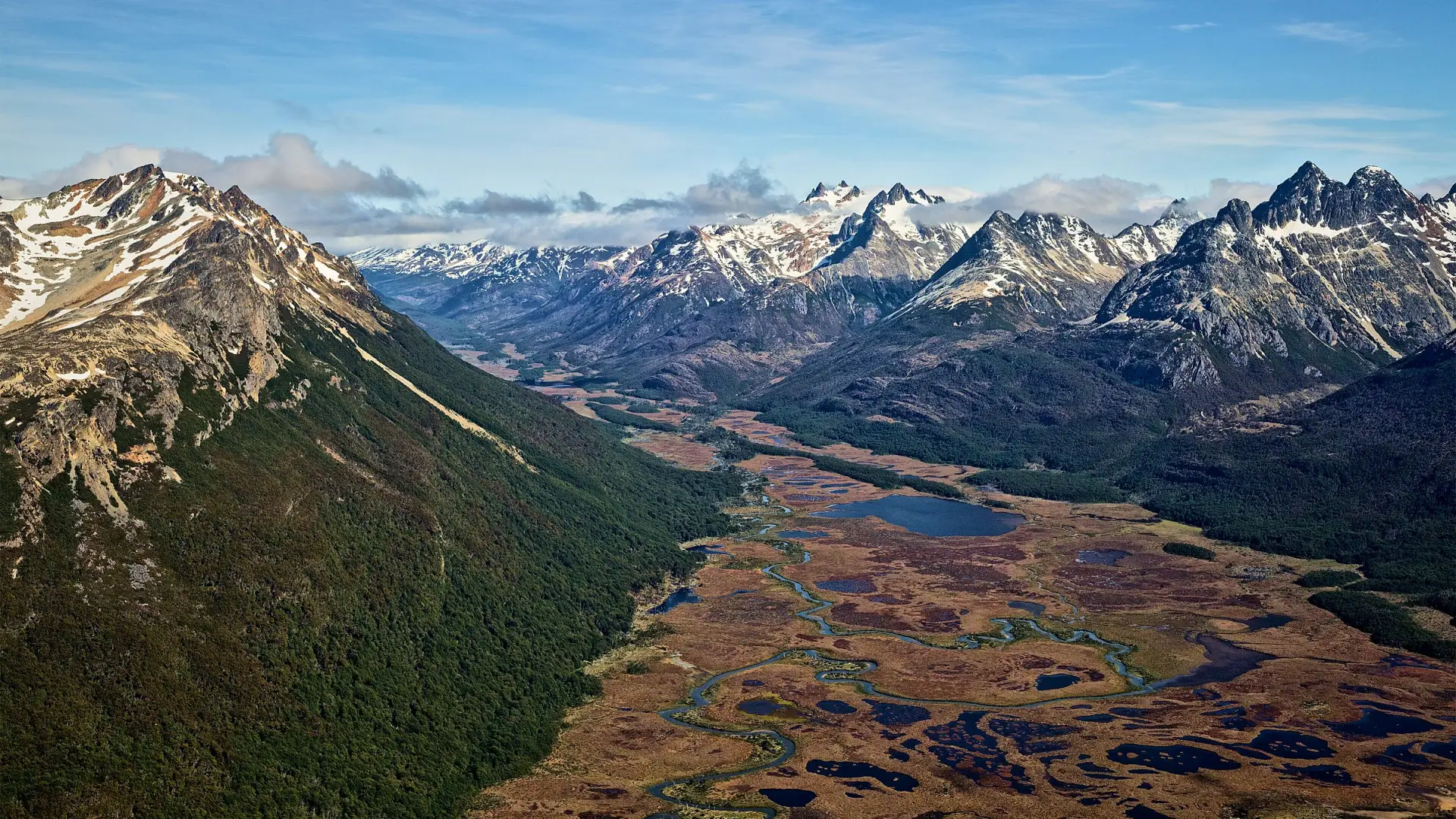 Vista aérea del Valle Carbajal, cerca de Ushuaia: turbales, un río que serpentea y montañas nevadas